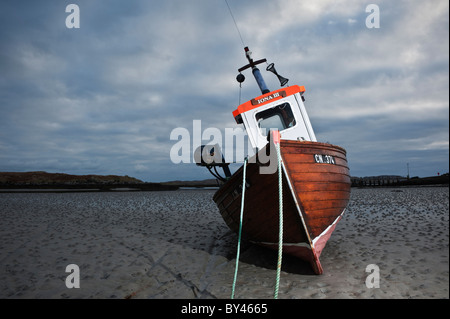 Fishing boat sits on habour sand at low tide, Ludag, South Uist, Outer Hebrides, Scotland Stock Photo