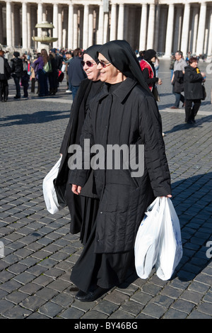 nuns walking in saint peter's square with shopping bags shoppers  vatican city san pietro Rome Italy Stock Photo