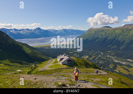 People hiking at the Alyeska Ski Resort in the Chugach Mountains in Girdwood Alaskawith Turnagin Arm in the distance Stock Photo