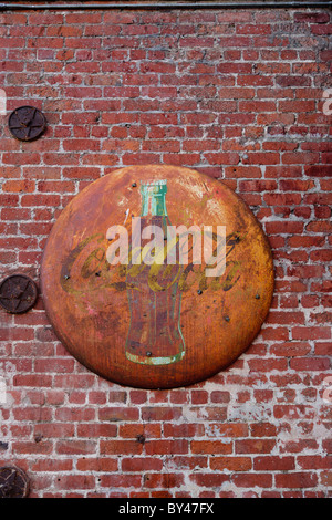 Faded Coca Cola sign on brick wall. Stock Photo