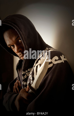 Young black youth model wearing a hoody holding a knife Stock Photo