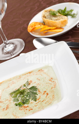 spinach cream soup with potato chips and fish pie Stock Photo