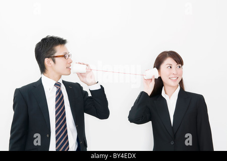 Businessman and businesswoman using tin can phone Stock Photo