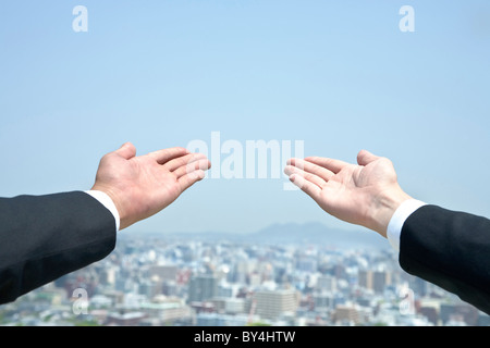 Two businessmen holding hands out Stock Photo