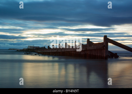 Sun rising over sea defences, Lossiemouth Stock Photo