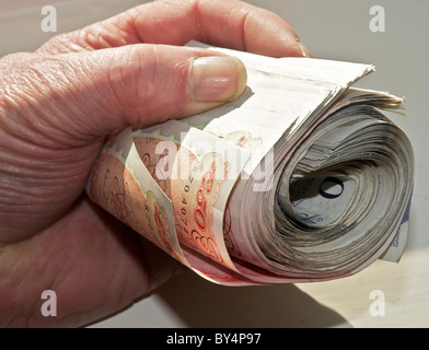 Sterling currency, a roll of UK bank notes thousand pounds in hand. (Fully released - photographer's own hand).  From the archives of Press Portrait Service (formerly Press Portrait Bureau) Stock Photo