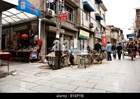 CHINA, XIAN: Typical street scene on a walking street in the Muslim Quarter of old Xian, crowded with people shopping Stock Photo