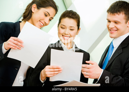 Portrait of three office workers interacting at business meeting Stock Photo