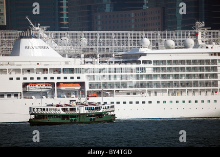 Star Ferry in front of a Cruising ship in Hong Kong Stock Photo