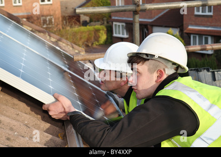 Installing photo voltaic solar panels onto the roof of a domestic house within Washington, North East England, UK Stock Photo