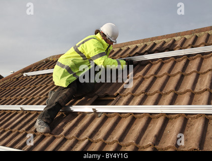 Installing photo voltaic solar panels onto the roof of a domestic house within Washington, North East England, UK Stock Photo