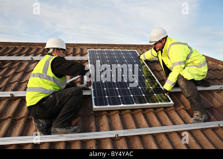 Installing photo voltaic solar panels onto the roof of a domestic house within Washington, North East England, UK Stock Photo
