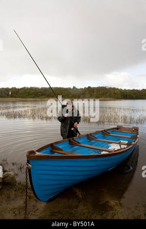 An angler prepares to go fishing in a loch in Western Ireland Stock Photo