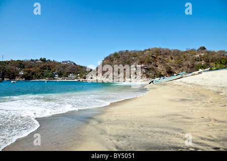 Playa Principal beautiful golden beach and blue crystalline water of Puerto Angel bay under clear blue sky Oaxaca State Mexico Stock Photo