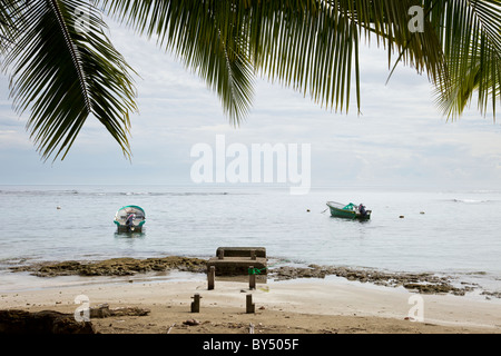 Two small fishing boats moored in front of the beach and palm trees in Puerto Viejo de Talamanca, Limon Province, Costa Rica. Stock Photo