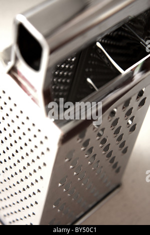A stainless steel cheese grater used in the kitchen to grate cheese Stock Photo
