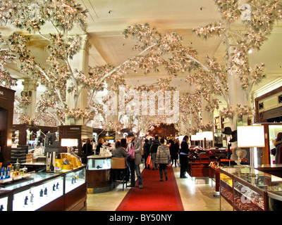 Indoor trees with electric lighted leaves decorate the Saks Fifth Avenue store at Christmas in New York City. Stock Photo