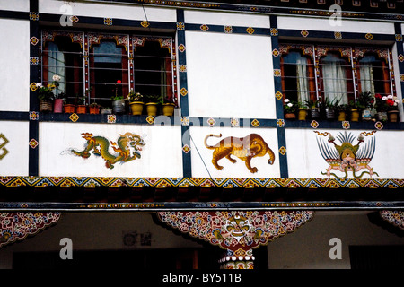 Colorful artwork in the typical Buddhist style adorns a traditional building in Paro, Bhutan Stock Photo
