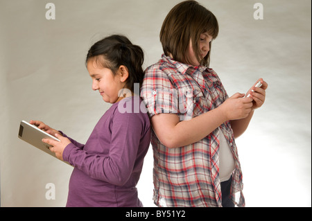 Two young girls playing electronic games on a touch pad screen Stock Photo