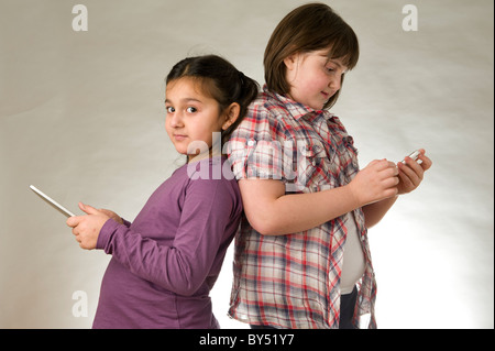 Two young girls playing games on touch pad screens Stock Photo