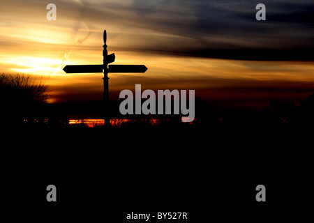 silhouetted crossroads signpost Stock Photo