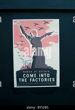 War poster on wall - Women of Britain come into our factories Stock Photo