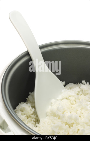 Cooked rice in cooker pot with plastic spoon on white background Stock Photo