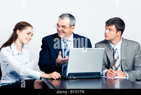 Communication of elderly boss with his managers in front of laptop at business meeting Stock Photo
