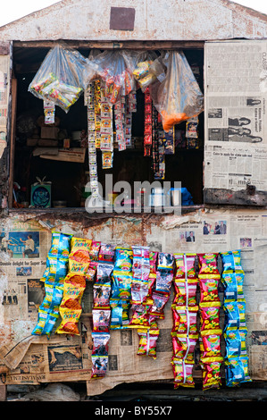 Dirty indian shop / shack selling packets of crisps on the road side. Andhra Pradesh, India Stock Photo