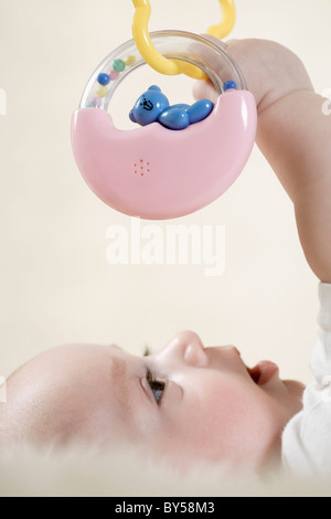 A baby reaching up to touch a mobile Stock Photo