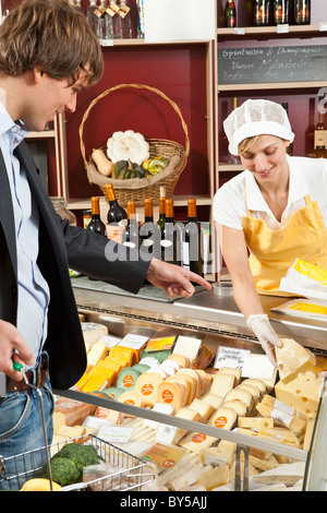 A customer and clerk in a wine and cheese shop Stock Photo