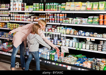 A mother and daughter shopping at the supermarket Stock Photo