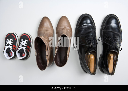 A child's shoes, a woman's boots and a man's shoes Stock Photo