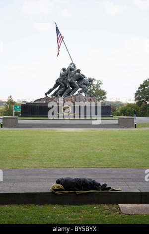 A homeless man sleeping in front of the Iwo Jima Memorial Stock Photo