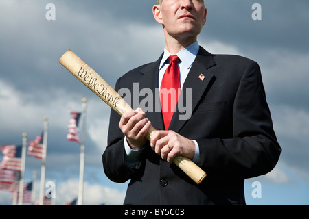 A politician holding a rolled up US Constitution Stock Photo