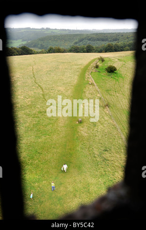 A family walking on The Cotswold Way path near North Nibley, Gloucestershire - viewed from a window in Tyndale's Monument - Augu Stock Photo