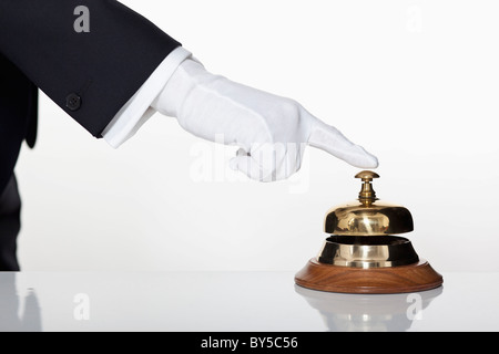 A butler pressing a service bell, focus on hand Stock Photo