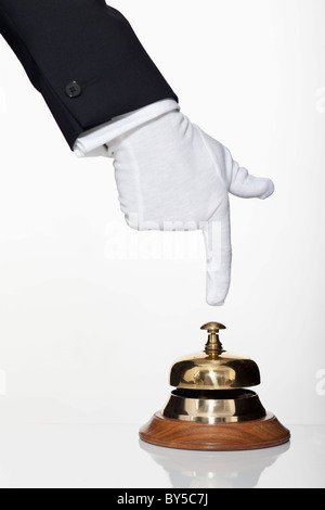 A butler pushing a service bell, focus on hand Stock Photo