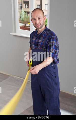 A building contractor using a tape measure Stock Photo
