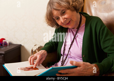 A senior woman pointing at a photograph in a photo album Stock Photo