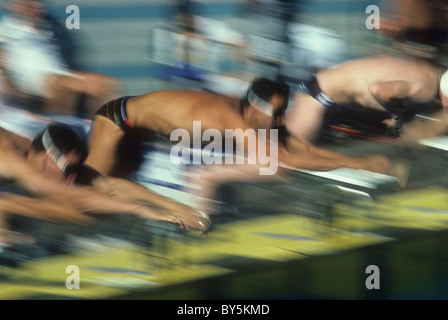 Blurred action of male swimmers at the start of a race. Stock Photo