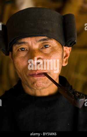 Old Jinuo man smoking pipe, Jinuo Luoke (Jinuo Shan), Jinghong, Xishuangbanna, Yunnan Province, China. JMH4316 Stock Photo