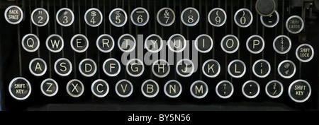 old typewriter keyboard with silver and black round keys with a black background Stock Photo
