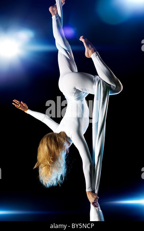 Young woman gymnast. On black background with flashes effect. Stock Photo