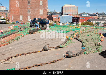 Commercial fishing nets with floats laid out in parking lot for repairs in Portland, Maine Stock Photo