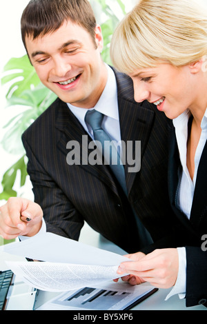 Vertical image of two smiling business colleagues discussing business documents in the office Stock Photo