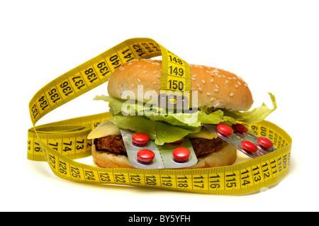 Hamburger with pills and measuring tape isolated in a white background Stock Photo