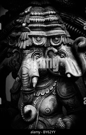 Hindu Elephant God, Lord Ganesha. Three headed hindu temple wooden statue. Monochrome Stock Photo