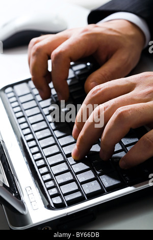 Male hands typing a business text on the laptop Stock Photo