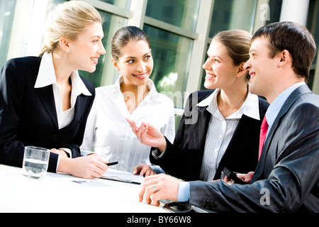 Portrait of four white collar workers discussing a new plan Stock Photo